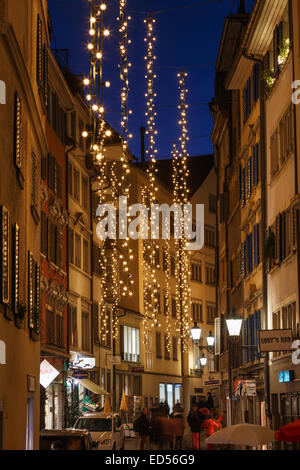 Eine Gasse in der Altstadt von Zürich in der Nacht mit Weihnachtsbeleuchtung, Schweiz. Stockfoto