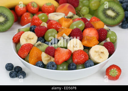 Obstsalat in einer Schüssel mit Früchten wie Erdbeeren, Kiwi, Heidelbeeren und Aprikosen Stockfoto