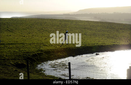 Ditchling Beacon, Sussex, UK. 28. Dezember 2014. UK-Wetter: Läufer Arbeiten aus den Exzessen von Weihnachten über den South Downs Way bei Ditchling Beacon am frühen Morgen. Stockfoto