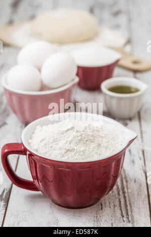 Teig Rezept Zutaten wie Eiern, Mehl, Öl, Zucker, auf weißen Holztisch Stockfoto