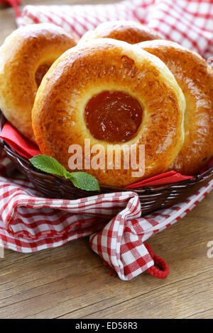 Runde süße Brötchen mit Apfelkonfitüre in einem Weidenkorb Stockfoto