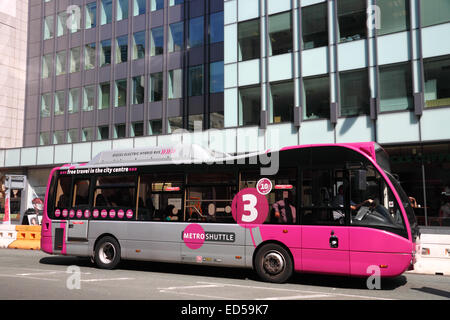 Ein rosa und grauen Hybrid-Diesel und Elektro "Bus neben einem modernen Bürogebäude in Manchester. Stockfoto