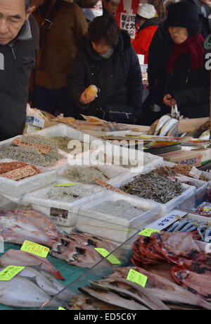 Tokio, Japan. 27. Dezember 2014. Nahe dem Gefrierpunkt Temperatur ungeachtet, Zehntausende von Großhändlern, Einzelhändlern, Makler, füllen Käufer und Touristen die engen Gassen, gesäumt von Hunderten von Anbietern und Mühle rund um Essen Ständen in Tokios Tsukiji-Fischmarkt am Samstag, 27. Dezember, am letzten Wochenende im Jahr 2014. Größte Markt der Welt, Hunderttausende von metroic Tonnen alle Arten von Meeresfrüchten, fielding zieht etwa 42.000 Besucher täglich. © Natsuki Sakai/AFLO/Alamy Live-Nachrichten Stockfoto