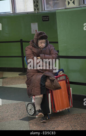 Müde ältere obdachlose Frau in einer U-Bahn Station aus der Kälte. NYC. Stockfoto