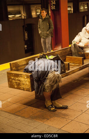 Psychisch Kranke, Obdachlose und kranke Frau in die 34th St. Der u-bahn Station in New York. Stockfoto