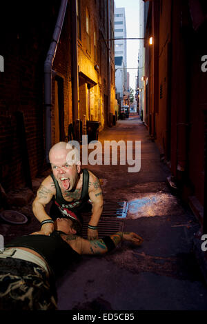 Die Ringer aus "The Half Pint Brawlers", "Marionette" und Eric Smallz Kämpfe in einer Gasse Stockfoto