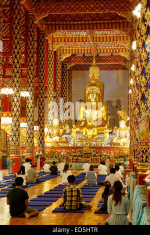Buddha-Statue und Anbeter, Gebetsraum, Wat Suan Dok, Chiang Mai, Thailand Stockfoto