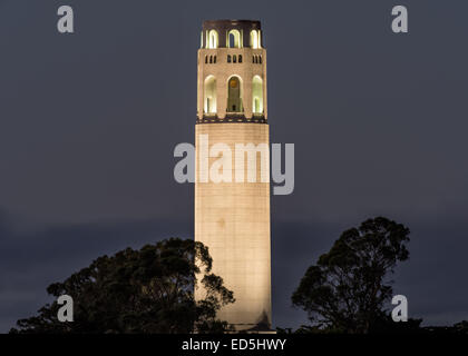 Coit Tower auf dem Telegraph Hill in San Francisco, Kalifornien, sitzt beleuchtet in der Dämmerung. Stockfoto