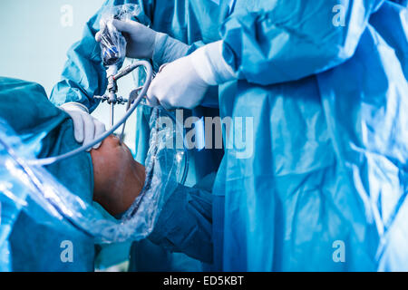 Knie-Chirurgie, orthopädische Operation - zwei Chirurgen, die Durchführung einer Knieoperation bei einem Patienten (flachen DOF; getönten Farbbild) Stockfoto