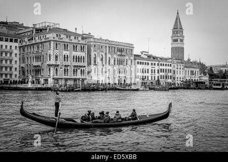 Venedig - Touristen auf Gondel mit Blick auf Saint Mark Campanile (Glockenturm) der Basilika von San Marco, Italien Stockfoto