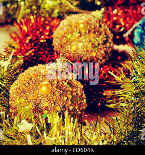 Bild von einigen Christbaumkugeln und Lametta in verschiedenen Farben, mit einem Retro-Effekt Stockfoto