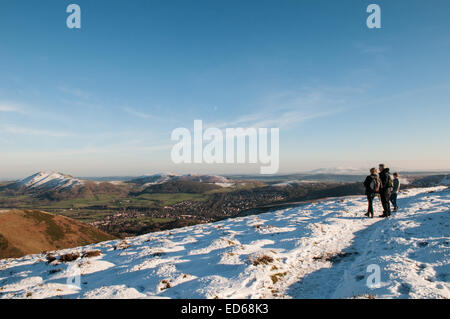 Shropshire, UK. 29. Dezember 2014. UK-Wetter: Drei Wanderer anhalten, um in die atemberaubende Winterlandschaft von der Spitze des Long Mynd in Shropshire, über die kuschelige Kirche Stretton, aufzunehmen, wie das Vereinigte Königreich genießt, strahlend blauem Himmel und Sonnenschein zusammen mit eisigen Temperaturen wie 2014 zu Ende geht und Menschen ihre Weihnachten und Neujahr Urlaub genießen. Bildnachweis: Jane Williams/Alamy Live-Nachrichten Stockfoto