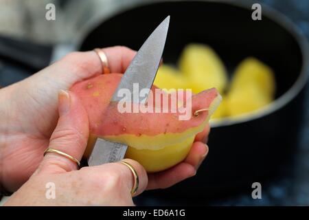 Rote Kartoffeln geschält wird von hand mit Messer in einer britischen Küche. Stockfoto