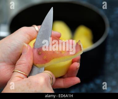 Rote Kartoffeln geschält wird von hand mit Messer in einer britischen Küche. Stockfoto