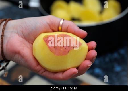 Rote Kartoffeln geschält wird von hand mit Messer in einer britischen Küche. Stockfoto