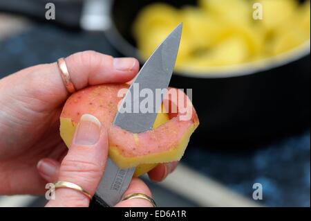 Rote Kartoffeln geschält wird von hand mit Messer in einer britischen Küche. Stockfoto