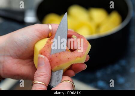 Rote Kartoffeln geschält wird von hand mit Messer in einer britischen Küche. Stockfoto