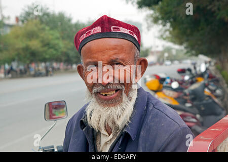 Nahaufnahme Portrait von älteren Uyghur Mann mit Bart tragen Doppa in Qiemo / Cherchen, Oasenstadt in der Provinz Xinjiang, China Stockfoto
