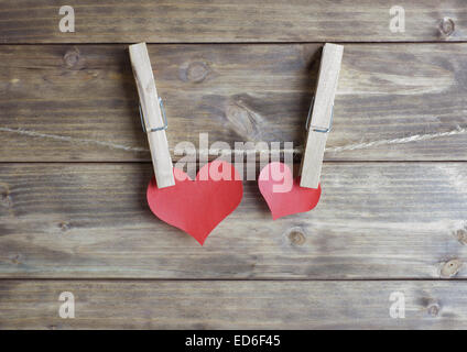 zwei rote Herzen mit Wäscheklammer an dem Seil hängen. Liebe-Konzept Stockfoto