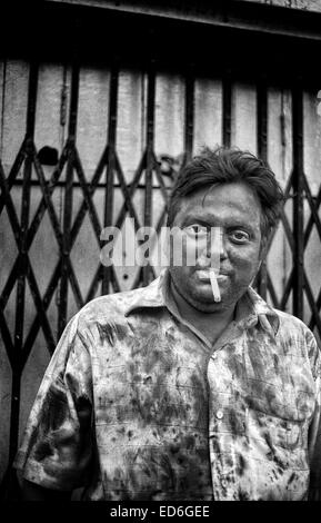 Kalkutta, Westbengalen, Indien. 11. April 2011. Porträt eines Mannes, Rauchen eine Zigarette auf den Straßen von Kalkutta während der Feier des Holi-fest. (März 2011) - Kolkata (Kalkutta) ist ein Wendepunkt auf dem indischen Subkontinent. Stadt eine herrliche koloniale Vergangenheit (ehemalige Hauptstadt von Britisch-Indien bis zum dem frühen zwanzigsten Jahrhundert) sieht jetzt wie andere Städte des Landes, Bombay oder Neu-Delhi, mit der Wirtschaft des Landes wachsen. In der Zwischenzeit bleibt die bengali Stadt verbunden, um das Stigma der Armut und Unterentwicklung seit dem Niedergang der Wirtschaft in den Jahren nach der Unabhängigkeit In Stockfoto