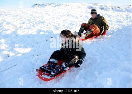 Lifestyle-Schuss älteres Ehepaar mit ihrem Enkel im Schnee Rodeln. Stockfoto