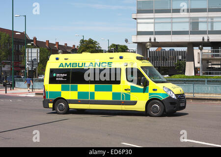 Ein Krankenwagen, um einen Kreisverkehr in Tolworth, Surrey, England reisen Stockfoto