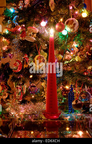 traditionelle beleuchteten Advent Kerze vor geschmückten Baum markieren den Countdown bis Weihnachten Stockfoto