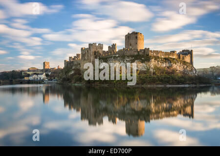 Pembroke Castle bei Sonnenuntergang mit Reflexionen in den Wassergraben Mühlenteich. Langzeitbelichtung verschwimmen Wolke Bewegung zu machen und Schloss abheben Stockfoto