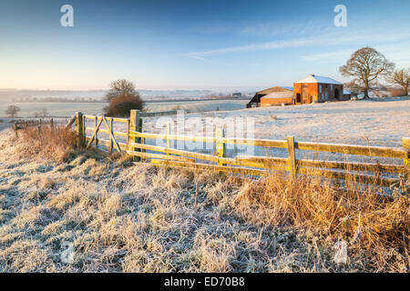 Northamptonshire, UK. 30. Dezember 2014. UK-Wetter.  Ein altes verlassenes Bauernhaus steht auf einem Bergrücken, getaucht in warme Sonnenstrahlen kurz nach Sonnenaufgang, umgeben durch eine winterliche Landschaft nach der schweren Nacht Frost, in der Nähe von Northampton in Northamptonshire. 30. Dezember 2014 aufgenommen. Bildnachweis: Andrew Baskott/Alamy Live-Nachrichten Stockfoto