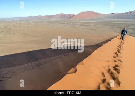 Aufsteigende Düne 45, mit Wind verursacht Flurries von Sand, Sossusvlei, Namib-Naukluft National Park, Namibia Stockfoto