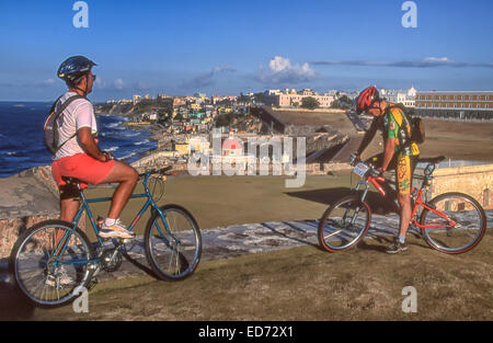 3. April 2001 - San Juan, Puerto Rico, US - zwei Radfahrer auf dem großen Vorplatz, der den berühmten Castillo San Felipe del Morro (Morro Schloß), historische Zitadelle aus dem 16. Jahrhundert auf der nordwestlichen Punkt der Insel von Old San Juan, Puerto Rico, bewundern Sie die Aussicht auf die Stadt. Unterhalb der Wand (Mitte) ist die rote Kuppel Neorenaissance-Kapelle des historischen Friedhofs. (Kredit-Bild: © Arnold Drapkin/ZUMA Draht) Stockfoto