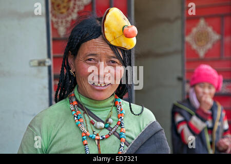 Porträt des tibetischen Khampa Frau trägt traditionelle gelb und rot Korallen Haarteil in Zhuqing, Provinz Sichuan, China Stockfoto