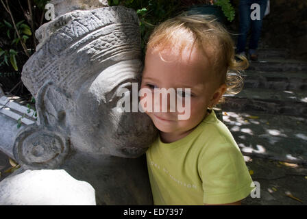 Kind posiert neben eine der Skulpturen und Statuen des Königspalastes. Phnom Penh. Kambodscha. Asien. Reisen Sie mit Kinder. Mädchen Stockfoto