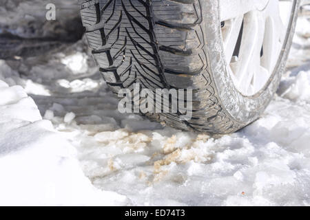 Winterreifen eines Autos auf einer verschneiten Straße Stockfoto