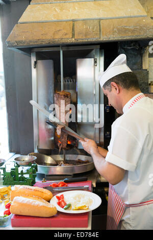 Küchenchef im türkischen Restaurant Ciya Sofrasi schneiden Lamm döner Kebab in Kadiköy Bezirk asiatische Seite von Istanbul, Ost-Türkei Stockfoto