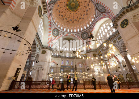 Touristen tragen Schals im Innenraum der Süleymaniye-Moschee in Istanbul, Türkei Stockfoto