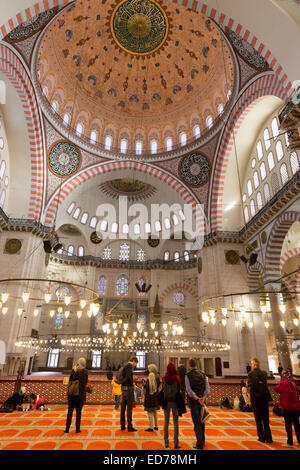 Touristen tragen Schals im Innenraum der Süleymaniye-Moschee in Istanbul, Türkei Stockfoto