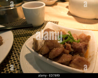 Gegrilltes Schweinefleisch mit schwarzen Bohnen-Sauce auf einer kleinen Dim-Sum-Platte in einem chinesischen Restaurant im Bundesstaat New York. Stockfoto