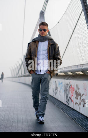 Hübscher trendigen Mann zu Fuß auf einer Brücke im winter Stockfoto