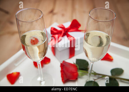 Sektgläser und rote Rose auf Tablett Stockfoto