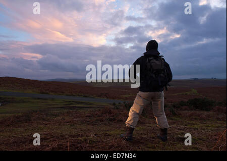 Mynydd Epynt, Powys, UK. 31. Dezember 2014. Eine Hügel Walker schaut die Sonne hinter Wolken in einem ominösen Himmel zum letzten Mal im Jahr 2014. Bildnachweis: Graham M. Lawrence/Alamy Live-Nachrichten. Stockfoto