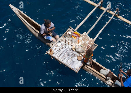 Melanesien, Papua Neu Guinea, Tufi. Dorfbewohner in hölzernen Einbaum mit Ausleger verkauft Muscheln und Kunsthandwerk. Stockfoto