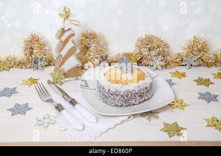 Festliche Kürbis-Kuchen mit Kokos auf Tisch und Weihnachtsdekoration. Hintergrund Bokeh. Reihe von Winter-Gebäck Stockfoto