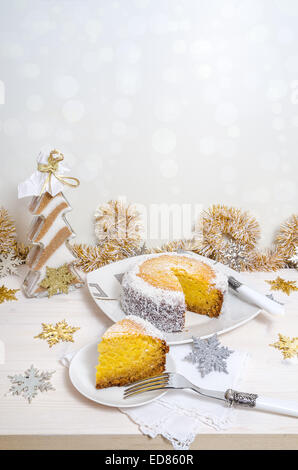 Festliche Kürbis-Kuchen mit Kokos auf Tisch und Weihnachtsdekoration. Hintergrund Bokeh. Reihe von Winter-Gebäck Stockfoto