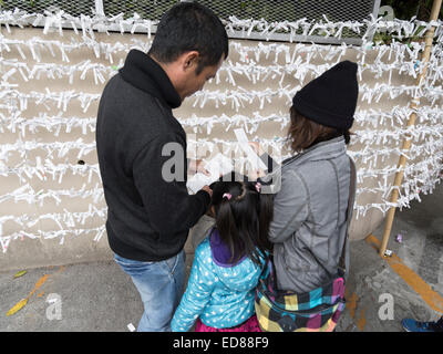 Silvesterfeiern im Futenma Schrein, Okinawa, Japan. 1. Januar 2015.  Familie lesen Omikuji Vermögen Papiere Credit: Chris Willson/Alamy Live News Stockfoto