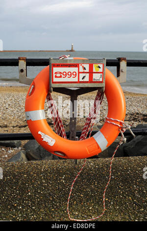 Ein Rettungsring in der Nähe von Roker Pier in Sunderland, England. 1. Januar 2015. Die Schwimmhilfe hat ein Schild mit Informationen über die Telefonnummer der Rettungsdienste. Stockfoto