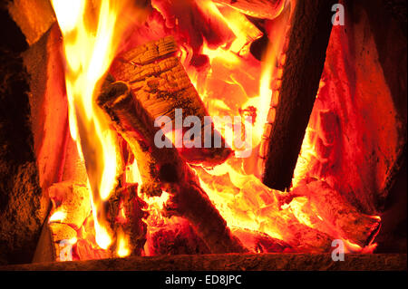 Herzlich Leuchten einer traditionellen Winter-Szene wie am offene Feuer in einem Haus leuchtende Licht strahlt, wie Holz Glut und Kohle heiß verbrennen Stockfoto