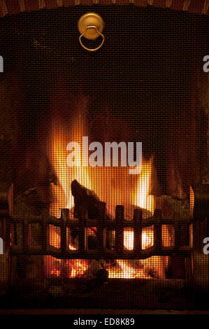 Herzlich Leuchten einer traditionellen Winter-Szene wie am offene Feuer in einem Haus leuchtende Licht strahlt, wie Holz Glut und Kohle heiß verbrennen Stockfoto