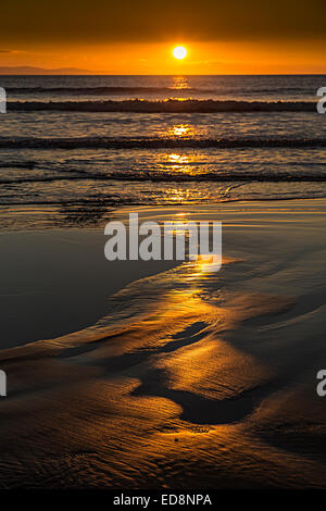 Reflexionen des Sonnenuntergangs im Sand am Strand, Southerndown, Glamorgan, Wales, UK Stockfoto