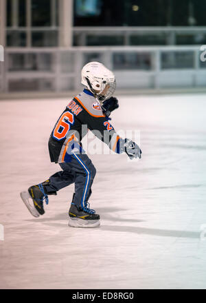 East Meadow, New York, USA. 31. Dezember 2014. Ein kleiner Junge, ein New York Islanders Eishockey Team Stil t-Shirt, Schlittschuhe vor die 5K Silvester Eve Strich, der Long Island Rat über Alkoholismus und Drogen Abhängigkeit (LICADD) am Twin RInks Ice Center Eisenhower Park auf Long Island zu unterstützen. Ein Skatin' Silvester Eve Veranstaltung begann Stunden früher und ein New Silvester-Party, offen für Läufer, Familie und Freunde weiter bis 02:30 Credit: Ann E Parry/Alamy Live News Stockfoto